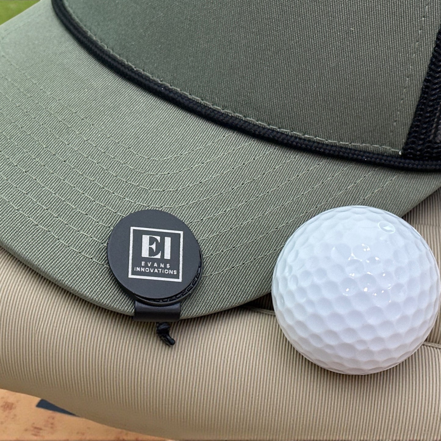 Customized golf marker hat clip with magnetic closure shown outdoors in natural light. Perfect for golfers, companies, and events looking for practical and memorable gifts. Laser engraved personalization highlights logos, initials, or tournament branding.