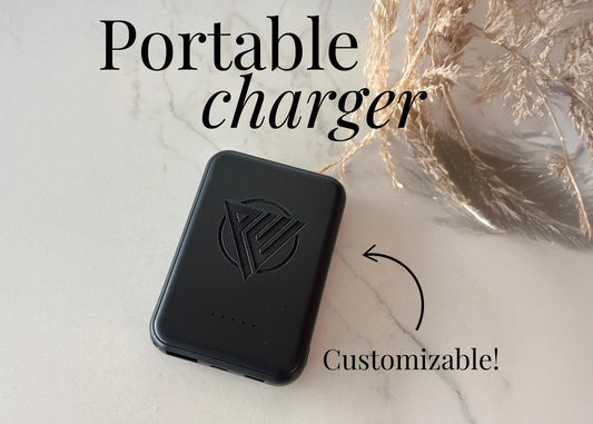 Black magnetic portable charger with slim, lightweight design shown charging a smartphone. This fast-charging power bank is ideal for travel, seniors, employees, teachers, or wedding gifts, available in blank or personalized engraved options.